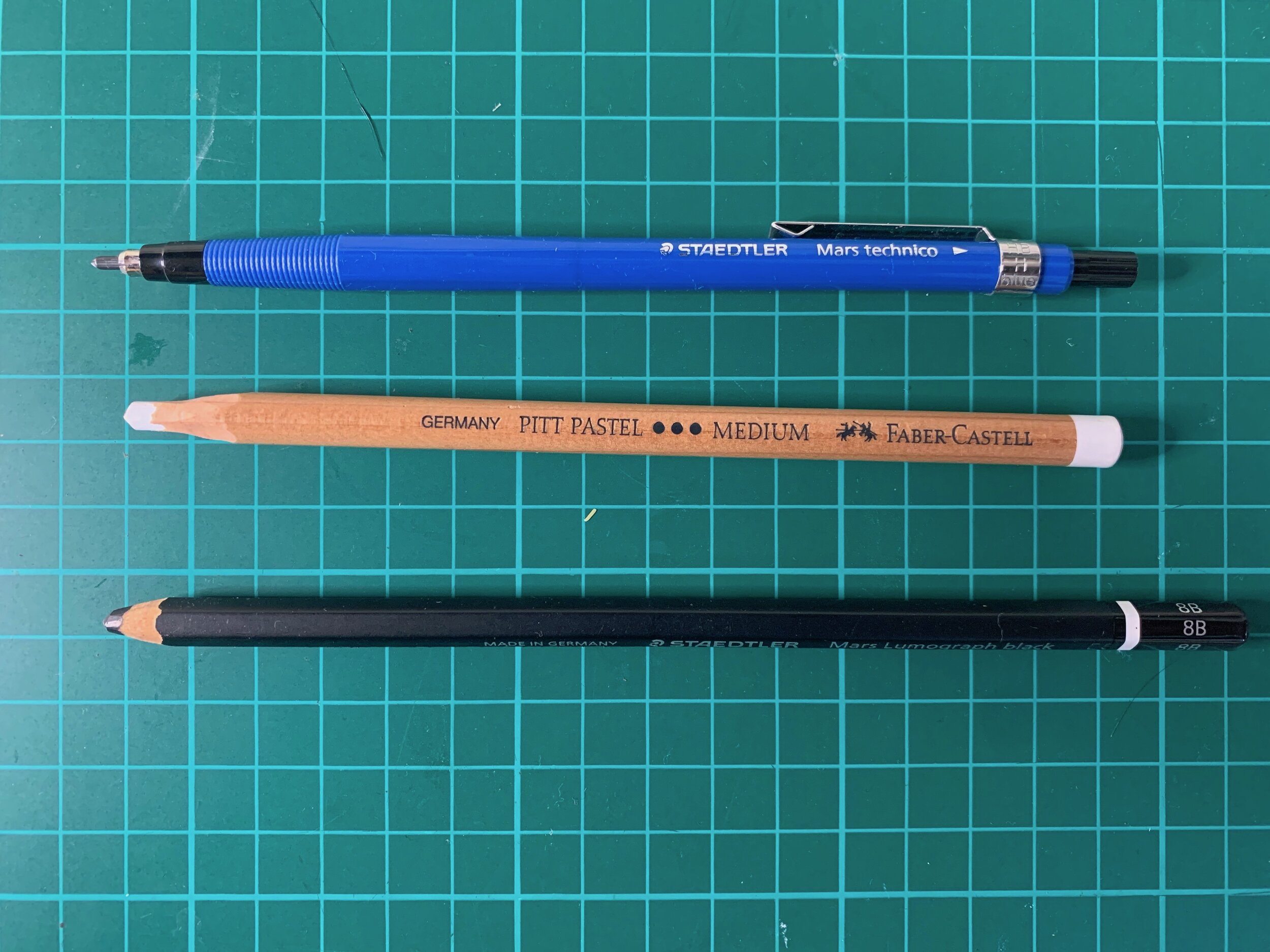 Mechanical pencil, white pastel pencil and Mars lumograph black pencil.